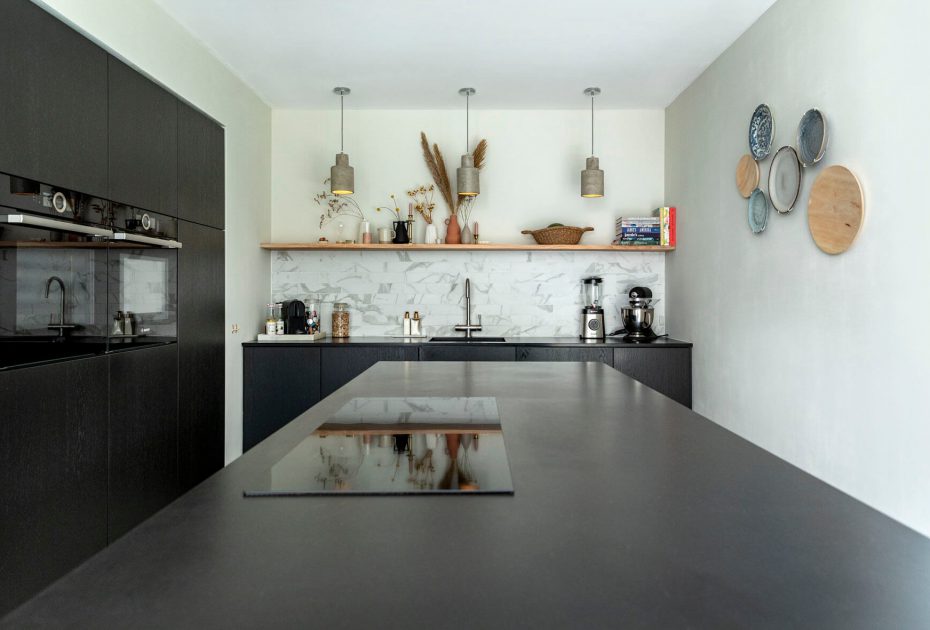 zwarte keuken met kookeiland en moderne inductie kookplaat