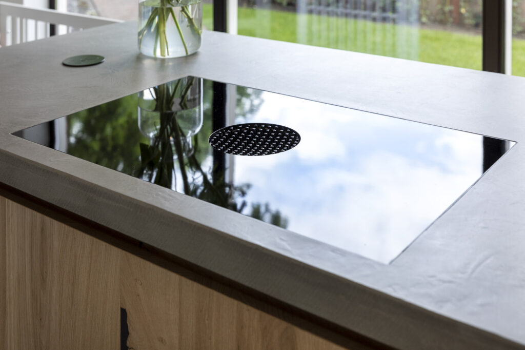 industriële keukens, keuken laten maken, keuken bouwer, op maat keukens, op maat gemaakte keukens, luxe keukens, vogels keukens Helmond, Nuenen, Waalre, Stiphout, Liessel, Helmond, Eindhoven, Bladel, Pijnacker, Rotterdam Vlakinbouw inductiekookplaat - Keuken in Regio Rotterdam, Koperkleurige spoelbakRonde deuren hoge kast, Composiet werkblad, Recirculatie schuine afzuigkap, Ronde vormen bij keuken, Keukenblad van Balsabeton "Robuste", Apparatenwand met rustiek eiken fineer, Wandmeubel passend bij keuken, Keukeneiland met Balsabeton werkblad, Industriële keuken met betonnen blad, Quooker reservoir weggewerkt achter ladefrontenDoorlopende houtnerf in fronten, Twist stopcontact in werkblad, Betonnen aanrechtblad met vlakinbouw kookplaat