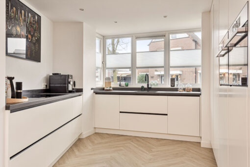 Moderne keuken Helmond, Keuken Brouwhuis, Witte moderne keuken, zwarte greeplijsten, zijdeglans lak fronten, zwarte grepen, witte keuken Helmond, moderne keuken, keuken met modern design, hoogwaardig keukenontwerp, stijlvolle keuken, luxe keuken, keukeninterieur, horizontale greeplijsten, horizontale zwarte greeplijsten, vlakinbouw kookplaat, kookplaat met afzuiging, kookplaat met geïntegreerde kookplaat, geïntegreerde kookplaat, inductiekookplaat met afzuiging, keramisch werkblad, keramische werkblad met veegplinten, Quooker kraan Flex, Franke Fragranite zwart, zwarte quooker. Zwarte verticale greeplijsten, verticale greeplijsten, kastenwand, apparatenwand, moderne keuken met apparatenwand, kastenwand met ovens.