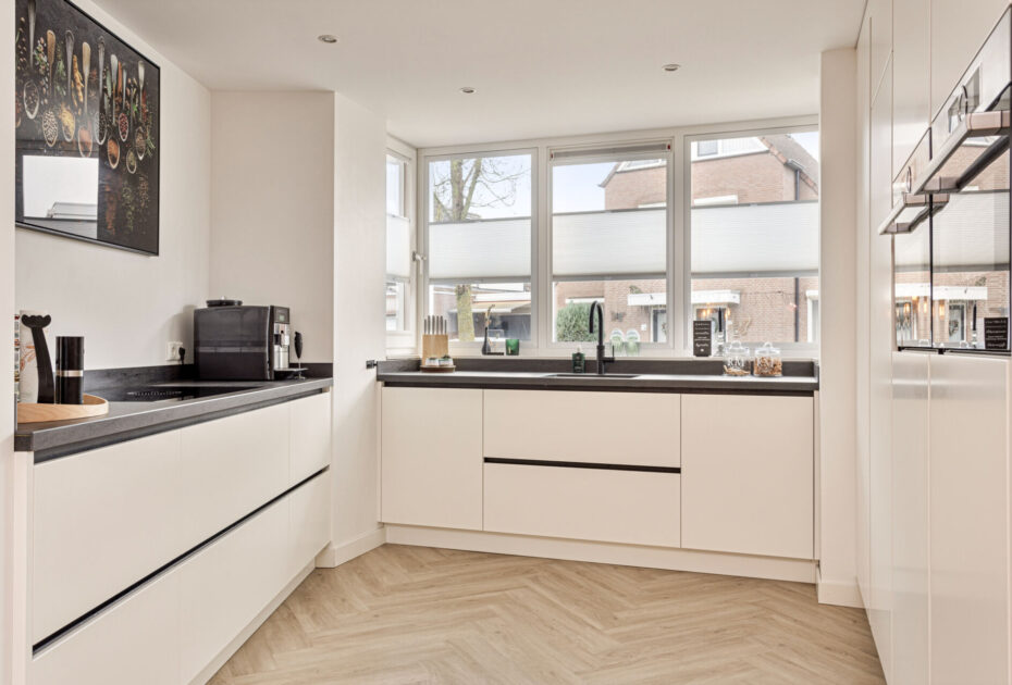 Moderne keuken Helmond, Keuken Brouwhuis, Witte moderne keuken, zwarte greeplijsten, zijdeglans lak fronten, zwarte grepen, witte keuken Helmond, moderne keuken, keuken met modern design, hoogwaardig keukenontwerp, stijlvolle keuken, luxe keuken, keukeninterieur, horizontale greeplijsten, horizontale zwarte greeplijsten, vlakinbouw kookplaat, kookplaat met afzuiging, kookplaat met geïntegreerde kookplaat, geïntegreerde kookplaat, inductiekookplaat met afzuiging, keramisch werkblad, keramische werkblad met veegplinten, Quooker kraan Flex, Franke Fragranite zwart, zwarte quooker. Zwarte verticale greeplijsten, verticale greeplijsten, kastenwand, apparatenwand, moderne keuken met apparatenwand, kastenwand met ovens.