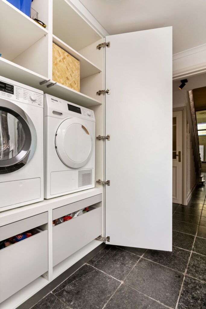 Moderne keuken Oosterhout, keukenstudio Oosterhout, keuken op maat Oosterhout, Moderne keuken Breda, keukenstudio Breda, keuken op maat Breda, composiet werkblad, hoekopstelling, Geïntegreerde Bora kookplaat met afzuiging, rvs vlakinbouw spoelbak, Gelakte fronten, push-to-open, Tip-On, wasmachinekast op maat, wasmachine op hoogte.