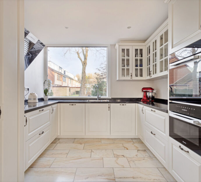 Klassieke keuken Delft, keukenstudio Delft, keuken op maat Delft, Klassieke keuken Rotterdam, keukenstudio Rotterdam, keuken op maat Rotterdam, composiet werkblad, Geïntegreerde kookplaat, rvs vlakinbouw spoelbak, Gelakte fronten, klassieke fronten, keuken met greep.