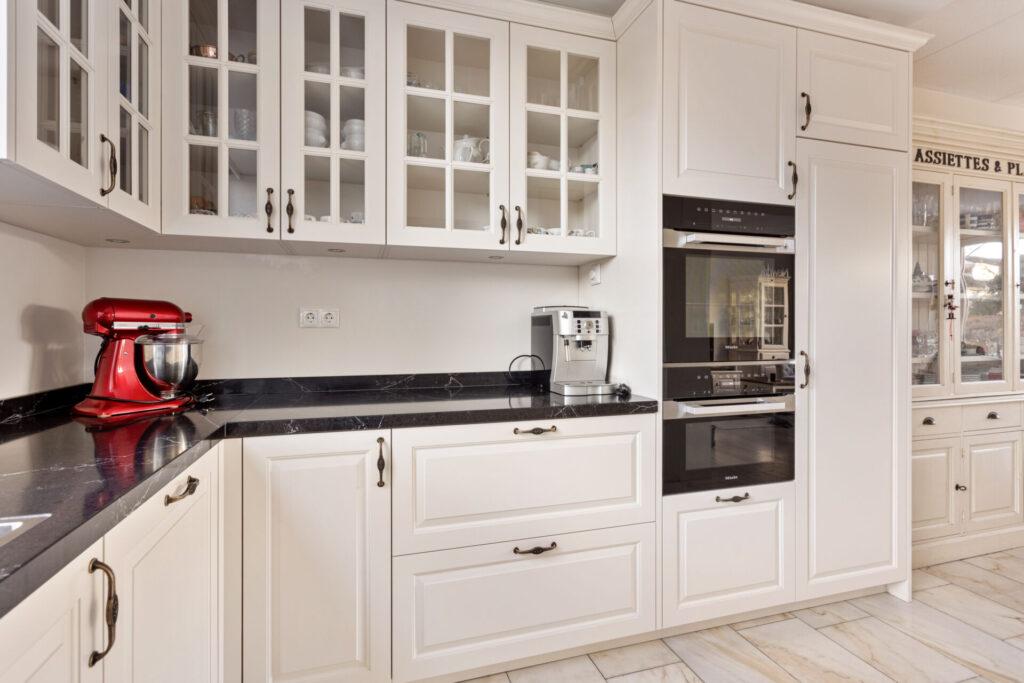 Klassieke keuken Delft, keukenstudio Delft, keuken op maat Delft, Klassieke keuken Rotterdam, keukenstudio Rotterdam, keuken op maat Rotterdam, composiet werkblad, Geïntegreerde kookplaat, rvs vlakinbouw spoelbak, Gelakte fronten, klassieke fronten, keuken met greep.