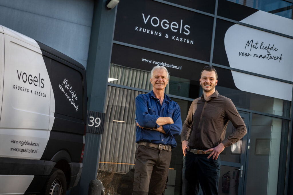 Twee medewerkers van Vogels Keukens voor het bedrijfspand en de bedrijfsbus