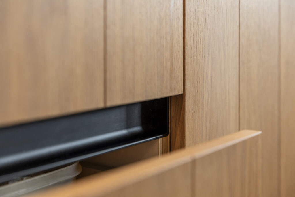 Detail van eiken kastdeur met greeploze zwarte inleg
