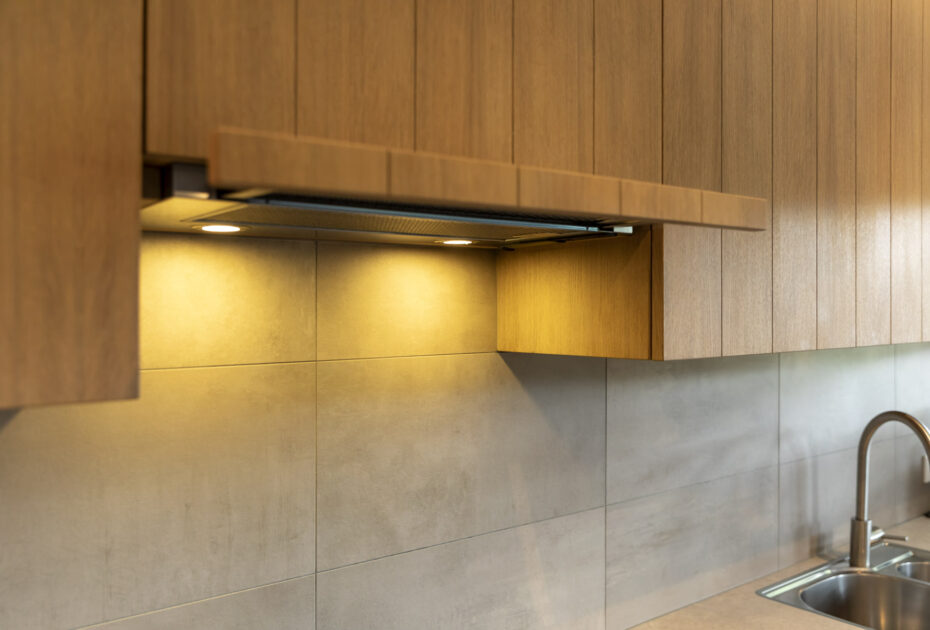 Detail van eiken afzuigkap met geïntegreerde verlichting boven rvs spoelbak