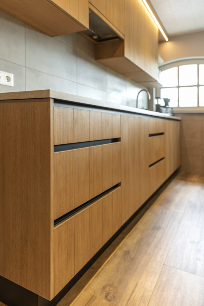 Eikenhouten keukenkasten met greeploze lades en verlichting onder bovenkasten