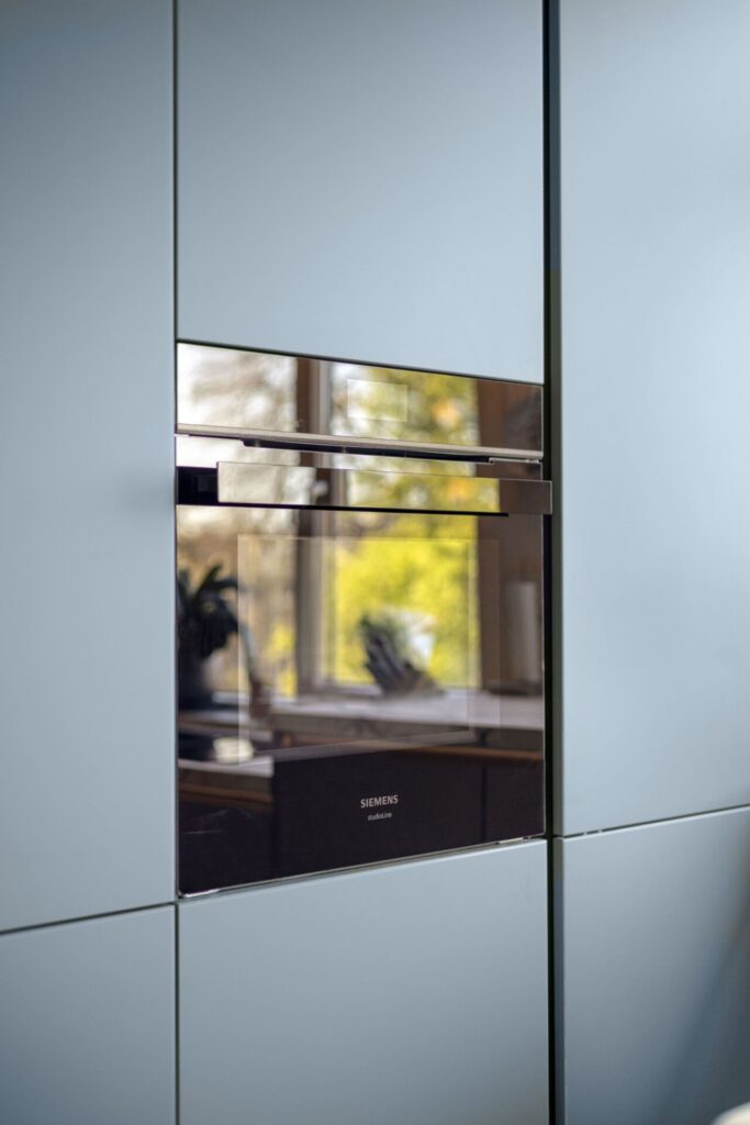 Lichtgrijze hoogglans keukenkasten met ingebouwde Siemens oven