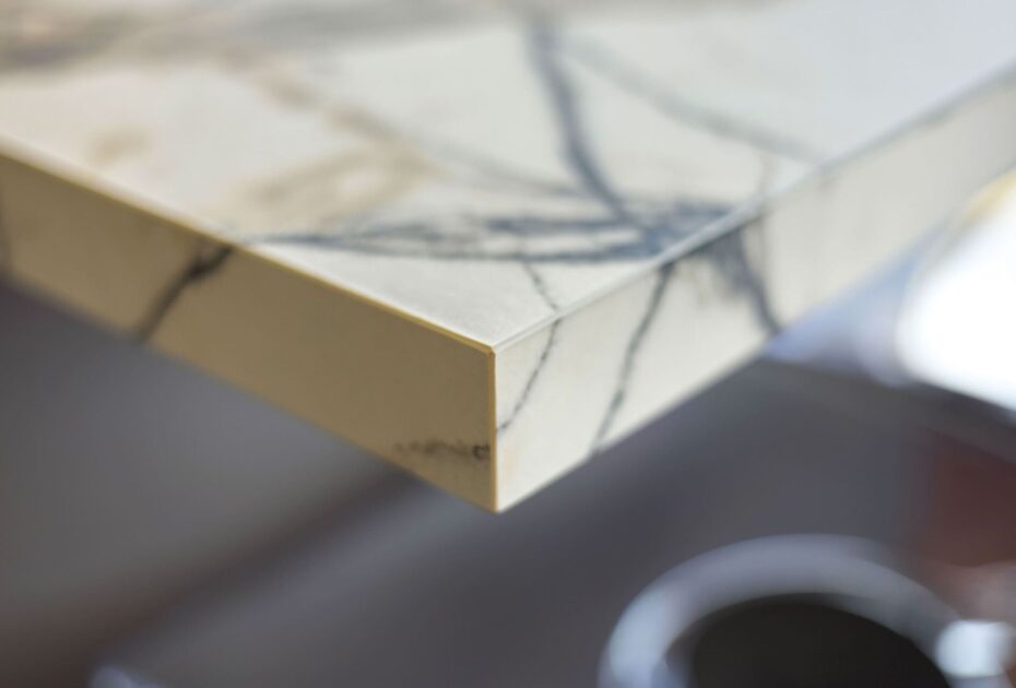 Close-up van marmerlook werkbladhoek met koffiekopje op de achtergrond